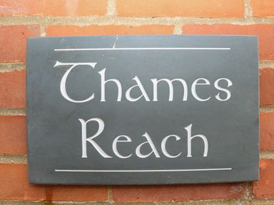 A sign on a brick wall with the text Thames Reach
