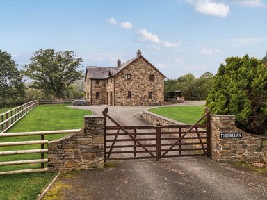 A house with a gate and driveway at Ty Berllan in Caersws