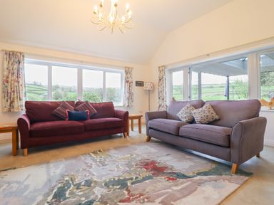 A living room with two sofas and a patterned rug at Ochr Y Garth in Maenan