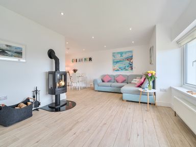 A living room with a fireplace and seating at Chi An Mor in Porth
