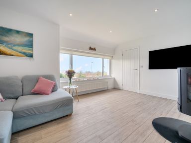 A living room with a sofa and television at Chi An Mor in Porth