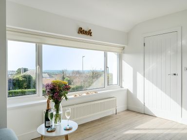 A living room with a window and flowers at Chi An Mor in Porth