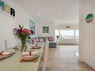 A dining room with a table and flowers at Chi An Mor in Porth