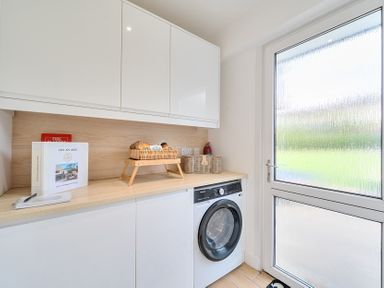 A laundry room with a washing machine and counter at Chi An Mor in Porth