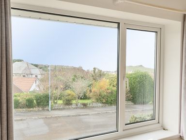 A view from a window showing houses and landscaping at Chi An Mor in Porth