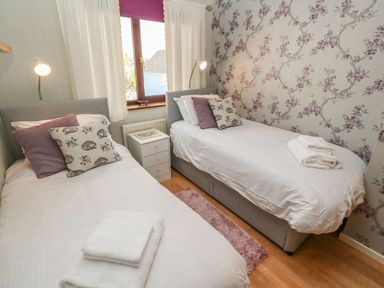 A bedroom with two single beds bedside table and a window at Phenests in Falmouth