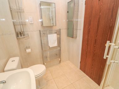A bathroom with a toilet sink towel rack and cabinets at Phenests in Falmouth