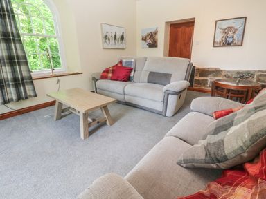 A living room with two sofas a wooden coffee table and plaid curtains at Beggars Roost in Penhallow