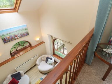 A seating area with two round chairs and a painting above a window at Beggars Roost in Penhallow