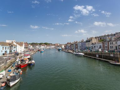 A harbor with moored boats and buildings along the waterfront at Brewers Quay Harbour