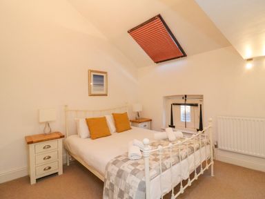 A bedroom with a bed two nightstands and a skylight window at Barley Mews in Brewers Quay Harbour