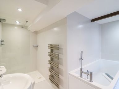 A bathroom with a shower area a bathtub a towel radiator and a washbasin at Barley Mews in Brewers Quay Harbour