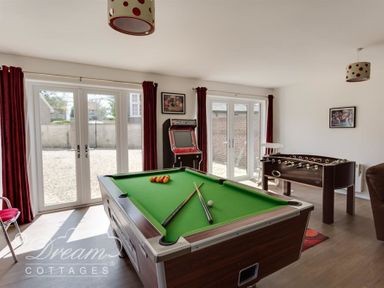 A game room with a pool table foosball table and arcade game at Baytree Lodge in Osmington