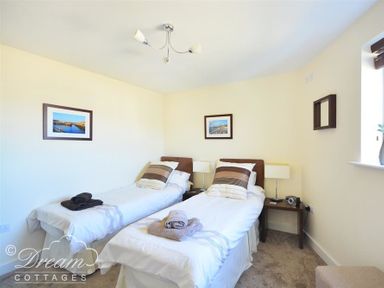 A bedroom with two single beds and bedside tables at The Boardwalk in West Bay