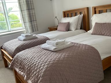 A bedroom with two beds at Bramble Cottage in Burton Bradstock
