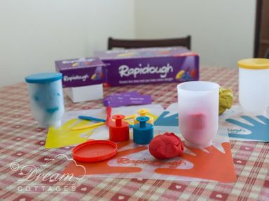 A table with play dough, plastic molds, and containers on a checkered tablecloth at Bridge Apartment in Weymouth
