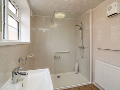 A bathroom with a sink and walk in shower with glass partition at Cliff Farm No 2 Cottage in Burton Bradstock