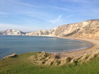 A coastal bay with cliffs beach and sea at Coombe Orchard in Swanage
