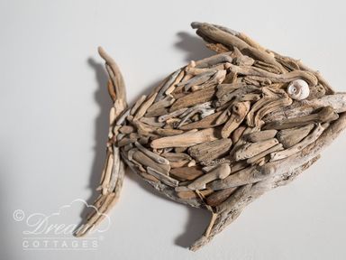 A wooden fish sculpture made of driftwood pieces on a wall at Dream View in Greenhill