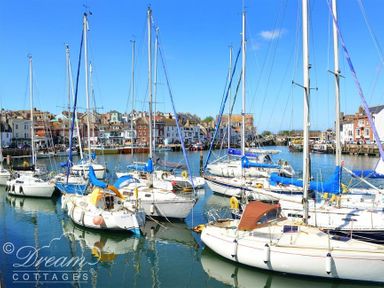 A harbor with sailboats docked and buildings along the waterfront at Dream View in Greenhill