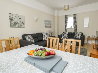 A living room with two sofas and a dining table with fruit bowl at Footprint in Brewers Quay Harbour