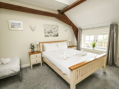 A bedroom with a double bed a single bed bedside tables and a window at Footprint in Brewers Quay Harbour