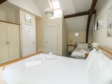 A bedroom with two beds a wardrobe and two doors under a skylight at Footprint in Brewers Quay Harbour