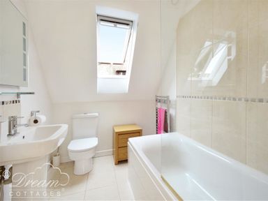 A bathroom with a sink toilet bathtub and storage unit at Fossil Barn in Weymouth