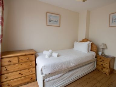 A bedroom with a single bed and wooden dressers at Georges House in Brewers Quay Harbour