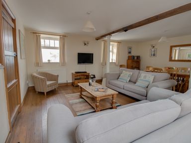 A living room with sofas a wooden coffee table a television and a dining table at Georges House in Brewers Quay Harbour