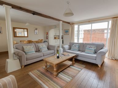 A living room with two sofas and a wooden coffee table on a striped rug at Georges House Brewers Quay Harbour