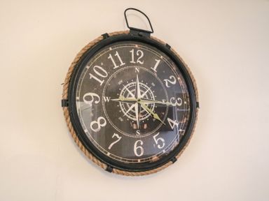 A round wall clock with rope border and compass design at Guinea Cottage in Brewers Quay Harbour