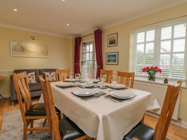 A dining room with a table set for six near windows and a sofa at Hops House Brewers Quay Harbour