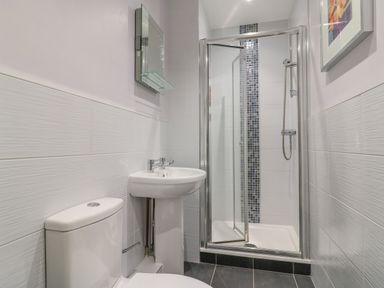 A bathroom with a toilet a pedestal sink a glass shower enclosure and a framed picture on the wall at Hops House Brewers Quay Harbour