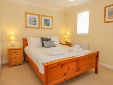 A bedroom with a wooden bed and two side tables with lamps at Hops House in Brewers Quay Harbour