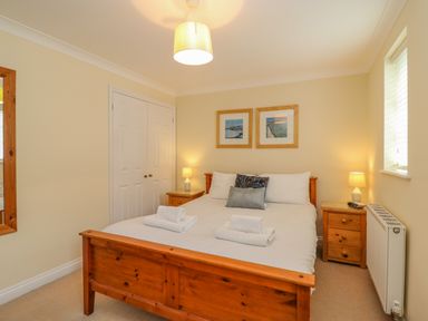 A bedroom with a wooden bed and bedside tables with lamps at Hops House in Brewers Quay Harbour