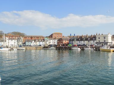 A harbor with boats docked near buildings along the waterfront at Brewers Quay Harbour