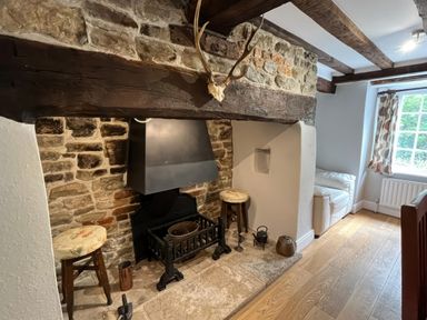 A living room with a fireplace and sofas at Ivy Cottage in West Lulworth