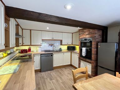 A kitchen with appliances and cabinetry at Ivy Cottage in West Lulworth