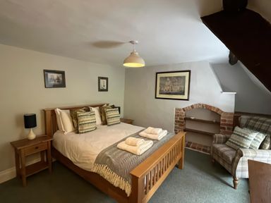 A bedroom with a bed and nightstand at Ivy Cottage in West Lulworth