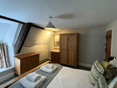 A bedroom with a bed and dresser at Ivy Cottage in West Lulworth