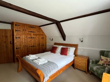 A bedroom with a bed and wardrobe at Ivy Cottage in West Lulworth