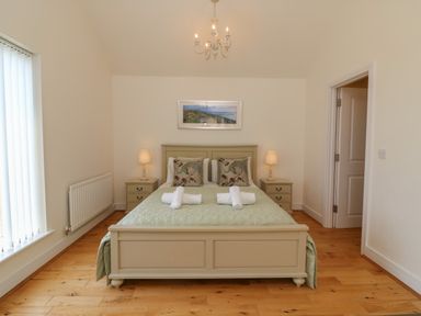 A bedroom with a double bed and two bedside tables with lamps at Jurassic Coast House in Portland