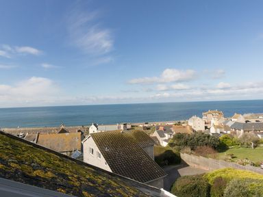 A coastal village with houses and a view of the sea at Langham Cottage in Portland