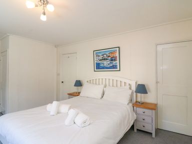 A bedroom with a bed and bedside tables with lamps at Lobster Cottage in Brewers Quay Harbour