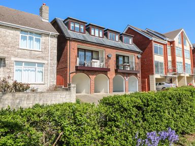 A row of houses with balconies arched garages and bushes in front at Lookout in Cove Castle