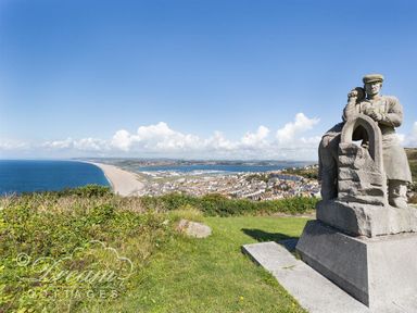 A coastal view with a statue overlooking a beach and town at Marina Vista in Weymouth