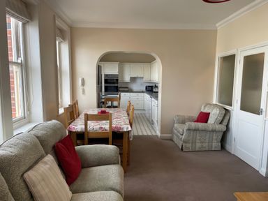 A living room with a dining table and kitchen in the background at Mutiny House Brewers Quay Harbour
