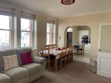 A living room with a dining table and kitchen view at Mutiny House in Brewers Quay Harbour