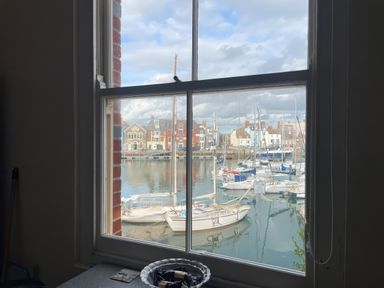 A view of boats in the water from a window at Mutiny House in Brewers Quay Harbour